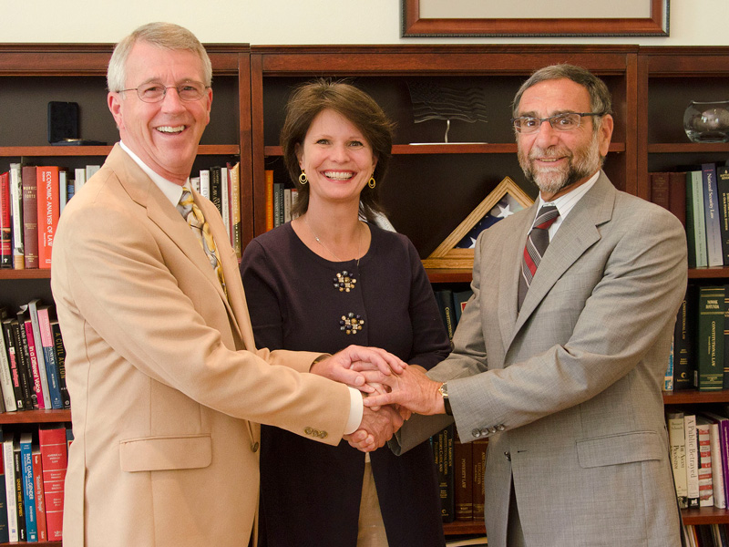 Larry and Nancy Peckham shaking hands with Nazareth College President Daan Braveman.