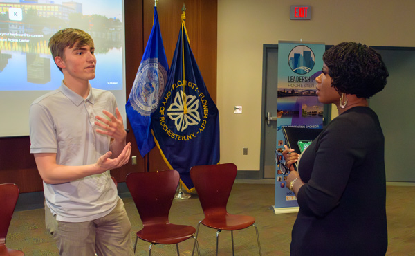 Jacob Koles talks with Leadership Rochester's leader during his community work