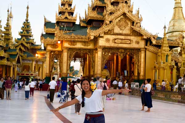 student standing in front of Asian temple