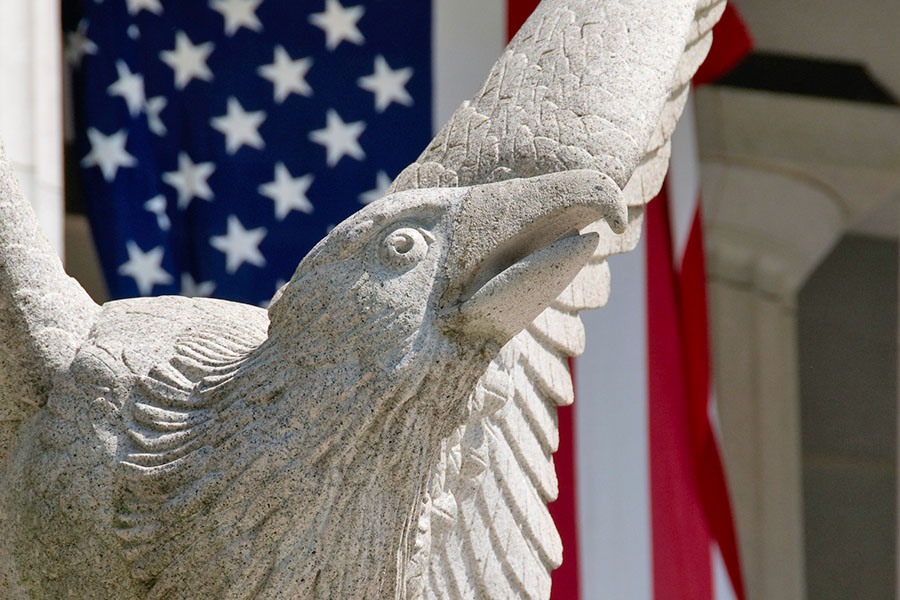 stone eagle statue in front of American flag