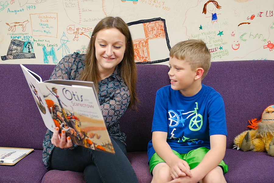 student reading book to a child