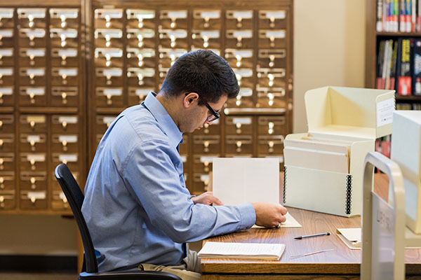 student seated at desk archiving papers