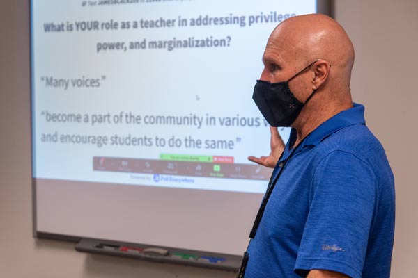 Jim Black teaching at a whiteboard, wearing a mask during the pandemic