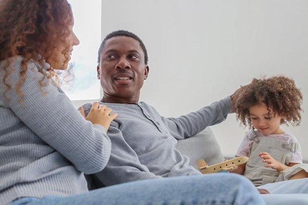 young couple and child sitting on a couch