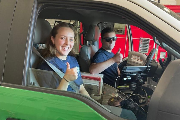 Emma Nichols gives a thumbs up sitting in a firetruck