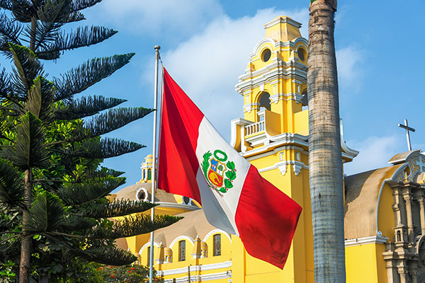 Peruvian flag flying in front of yellow building