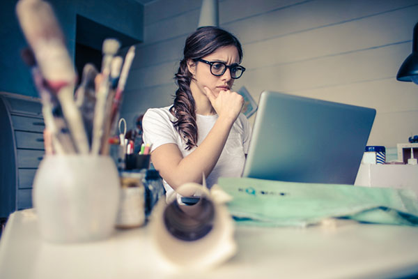 student looking confusedly at a laptop