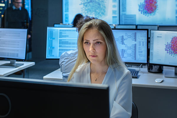 businesswoman amongst computer screens of data