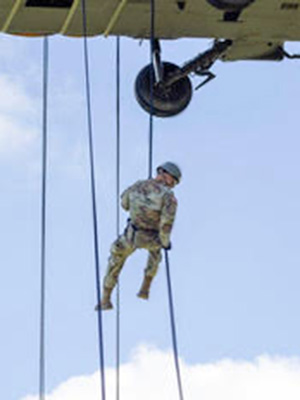 Karson LaRose hanging on rope below helicopter