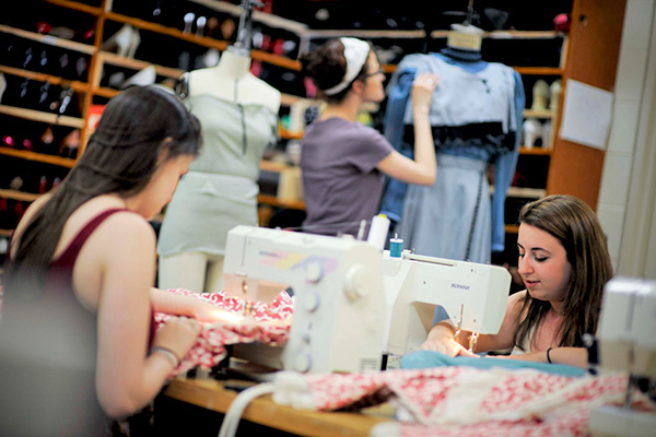 students sewing in backstage costume shop