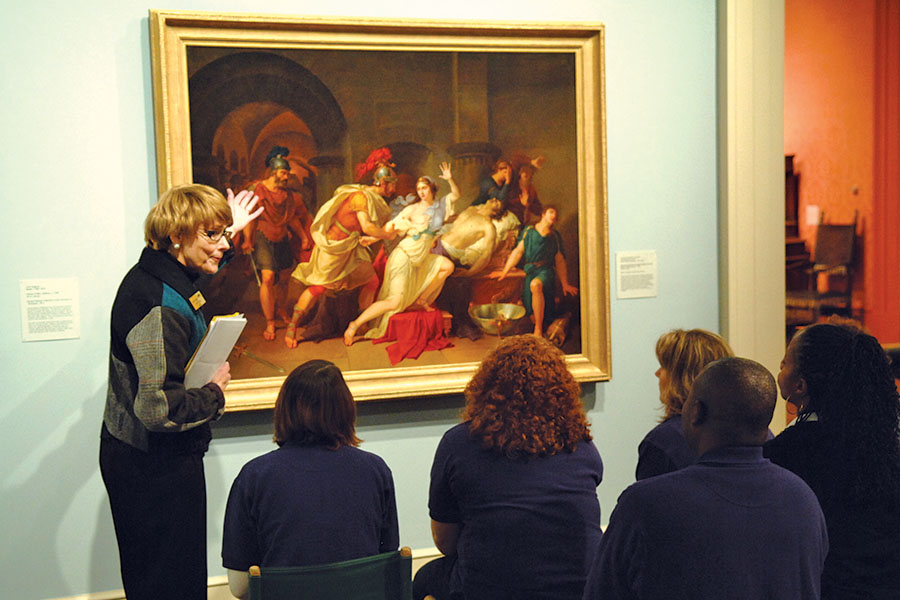 professor giving a lecture while pointing at a painting