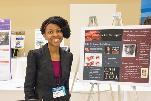 student standing next to project presentation board