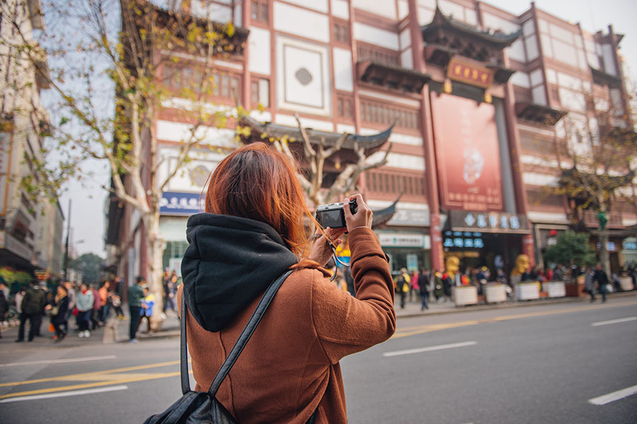 student taking a photo on street in Shanghai, China