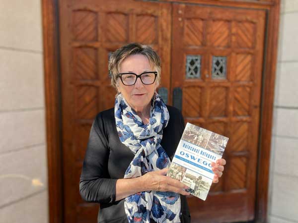 Ann Callaghan Allen holds her book, Holocaust Refugees in Oswego