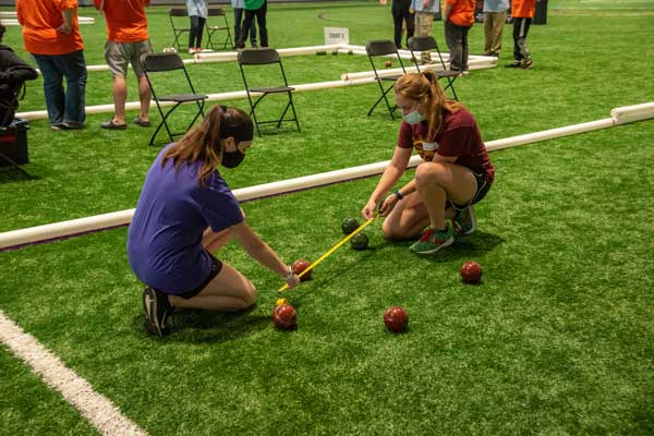 Students measure distances between bocce balls at a Special Olympics competition at Nazareth