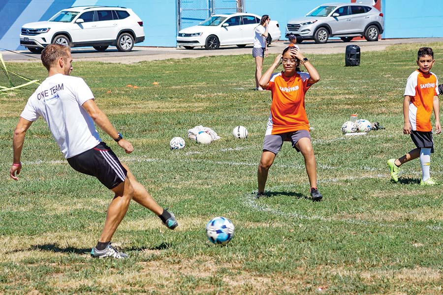 Liam Connolly playing soccer with children