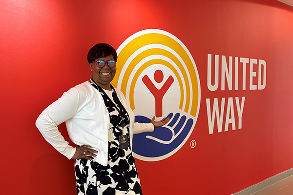 Lawana Jones stands by United Way Worldwide logo on wall