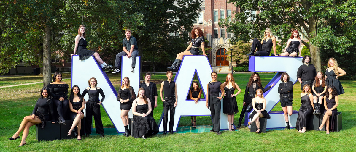Musical theatre class of 2026 students pose on and around the NAZ letters on campus