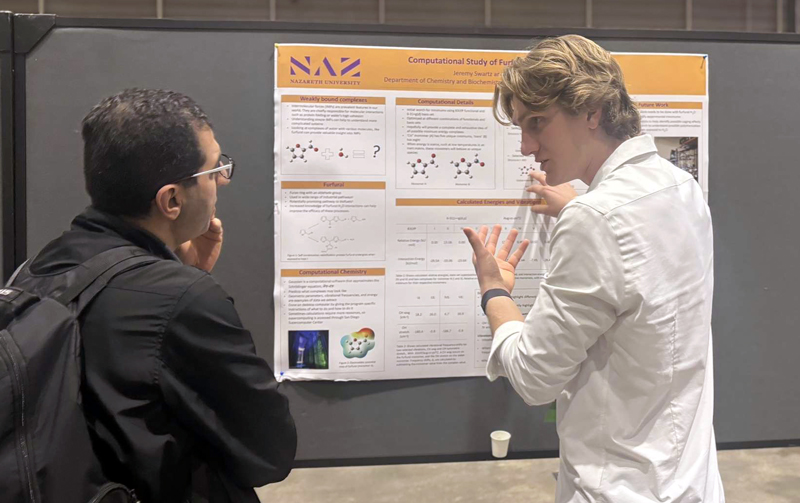 Jeremy Swartz discusses his research poster at Nazareth's symposium