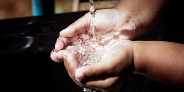 close up of hands holding water