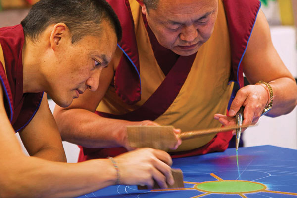Tibetan monks creating sand mandala