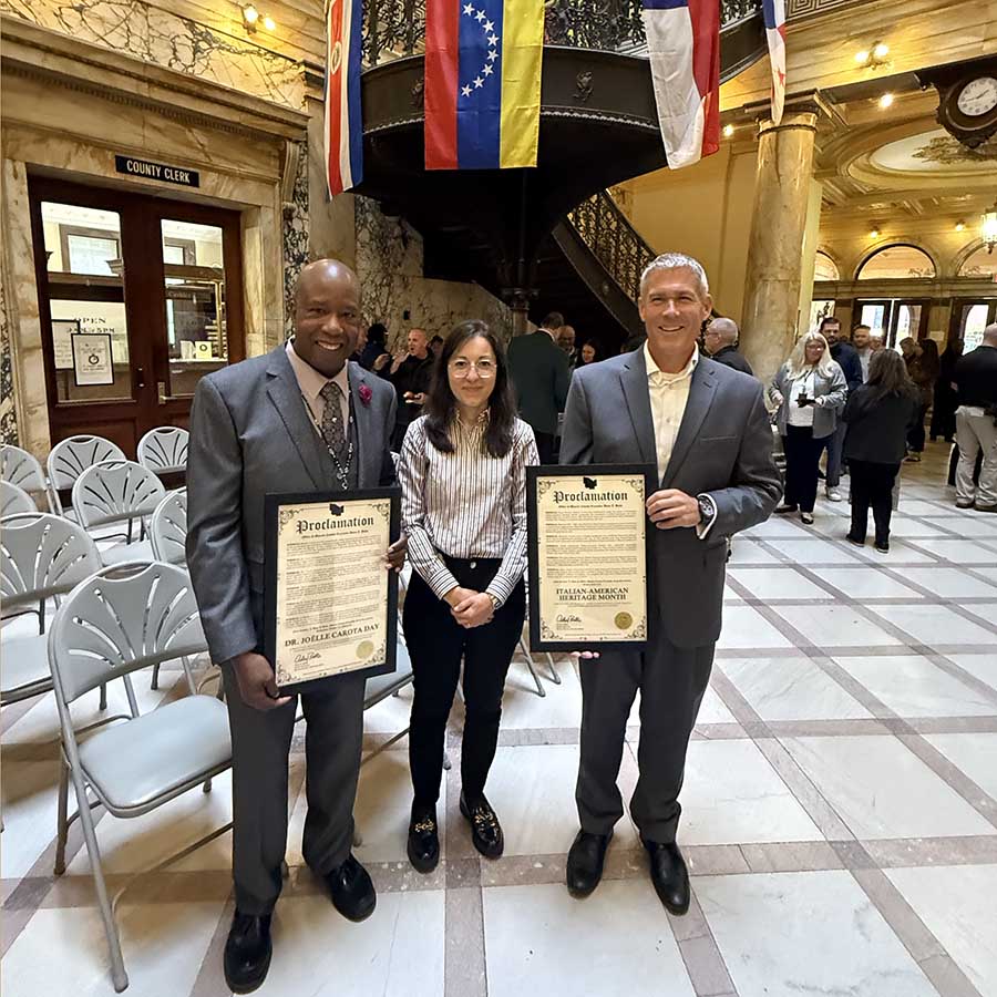 photo of Casa Italiana Director Joëlle Carota standing between Monroe County Chief Diversity Officer and County Executive, both who are holding awards