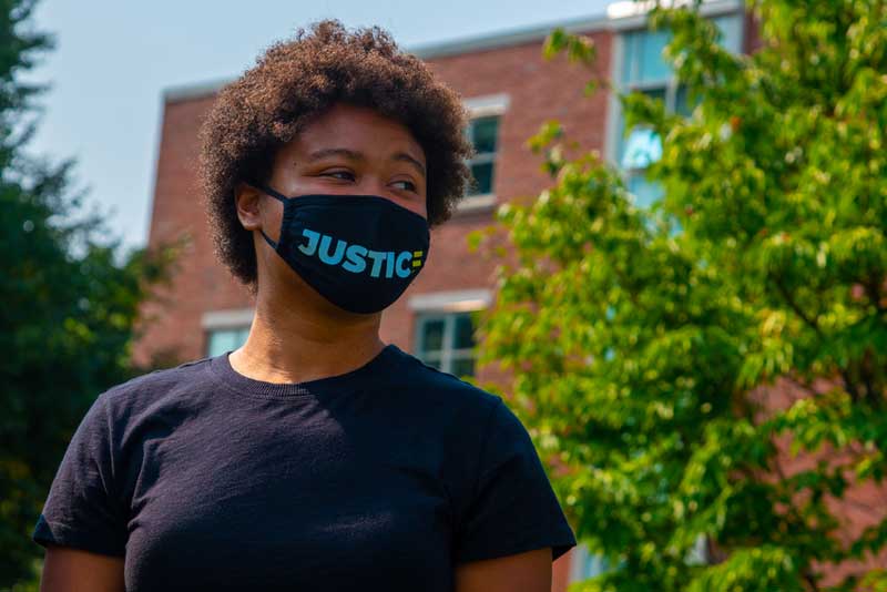 student with mask that says "justice"