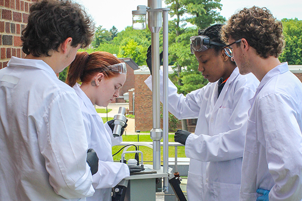 student scientists collecting samples outdoors