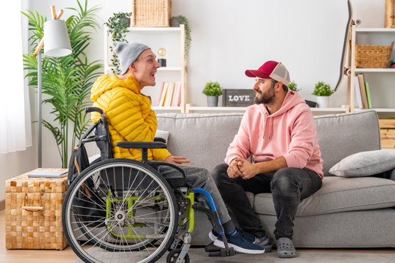 two men talk, one in a wheelchair