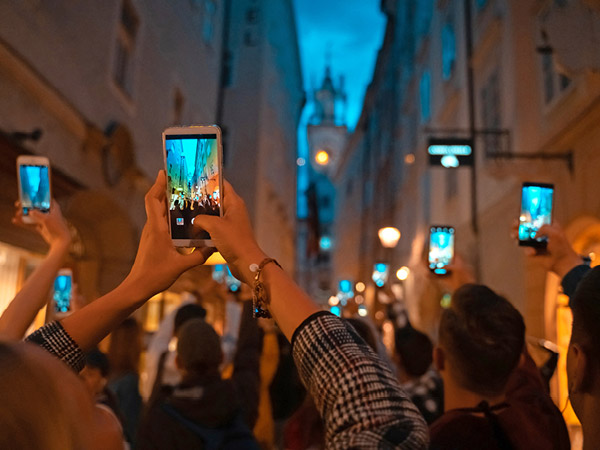 people on a street raising up their smartphones