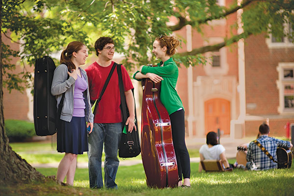 students outside carrying musical instrument cases