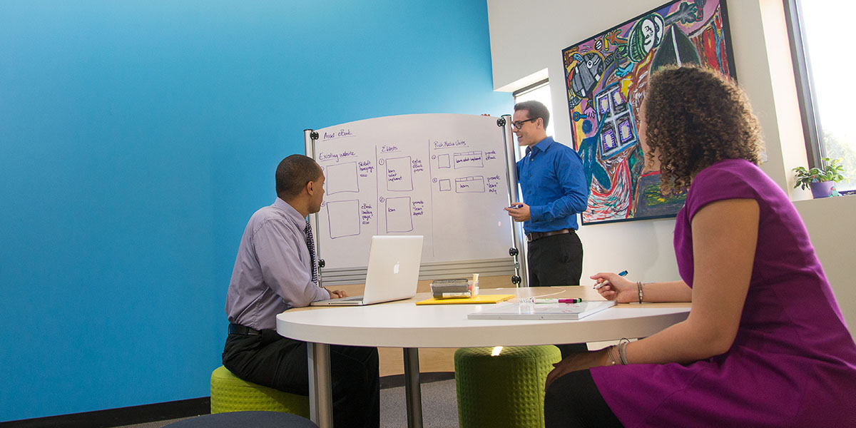 students drawing flowcharts on a whiteboard