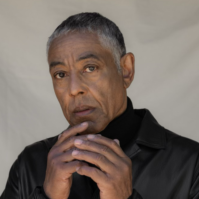 photo of actor Giancarlo Esposito with his hands touchin his chin and looking into the camera.