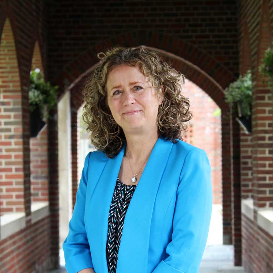 photo of Meg Callahan-Steckley in the covered walkway between Smyth Hall and the Shults Center on campus.