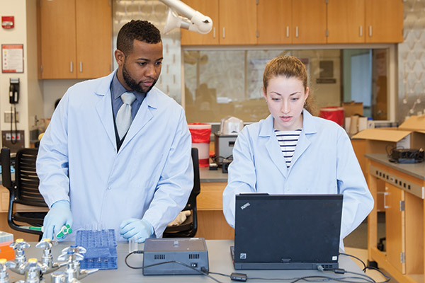 chemistry students taking notes on experiment