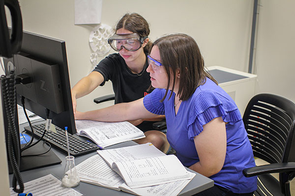 chemistry students analyzing data with computer