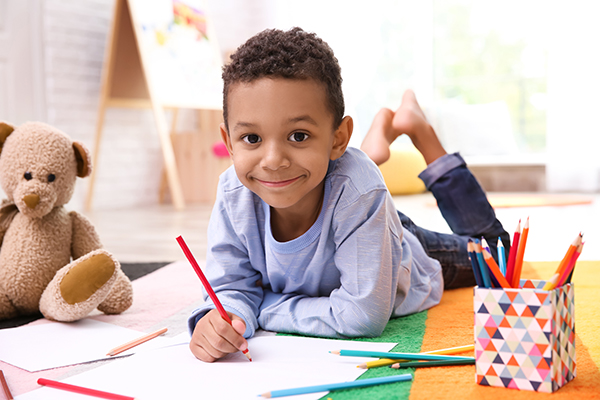 Boy smiling while drawing