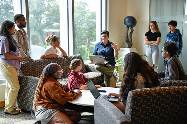 group of students in discussion with a professor