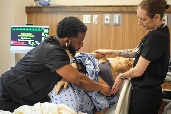 PA student using a stethoscope on a sim patent