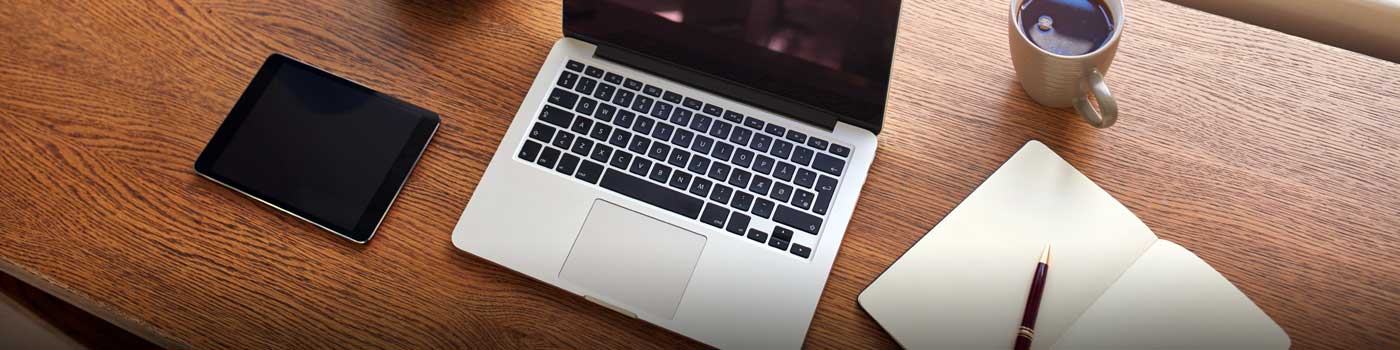 laptop computer on desk in front of window