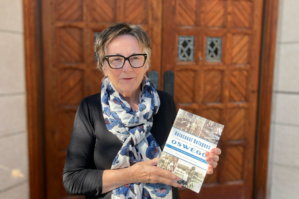 Ann Callaghan Allen holds her book about Holocaust Refugees in Oswego