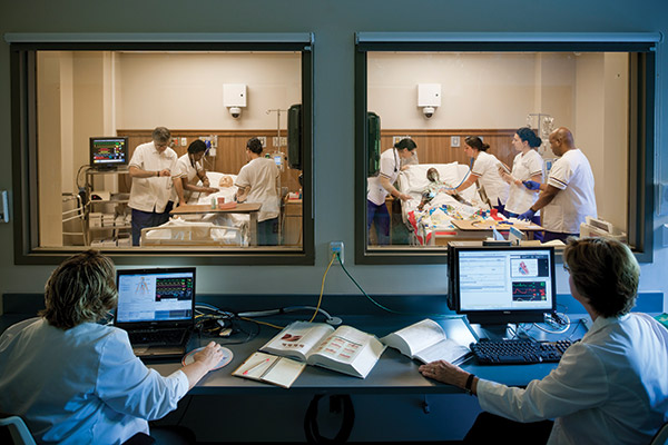 nursing faculty observing students in a nursing sim lab