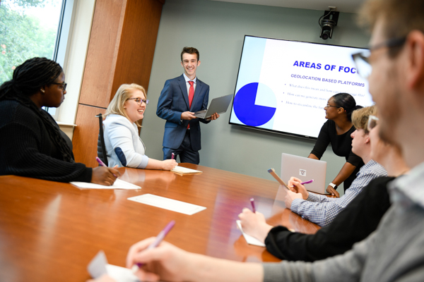 business students presenting in a boardroom