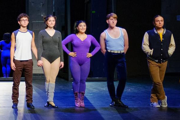 Isabel Simone standing on stage with fellow performers