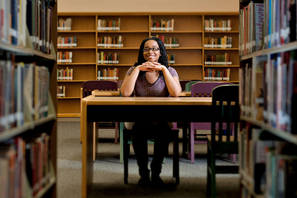 student sitting at a table in library