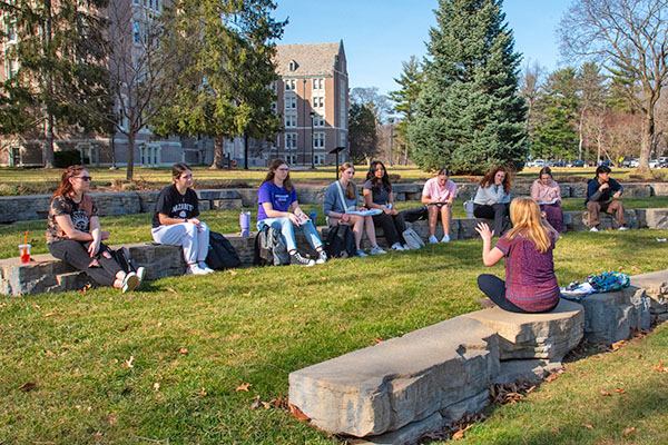 professor leading class outdoors in Garen Peace Garden