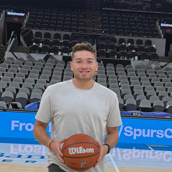Joaquin Romero holds basketball on San Antonio Spurs basketball court