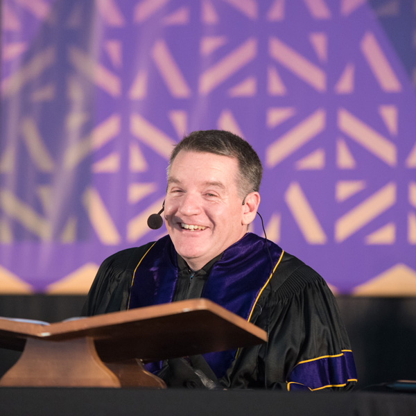 Chris Hilderbrant speaks at podium at Commencement