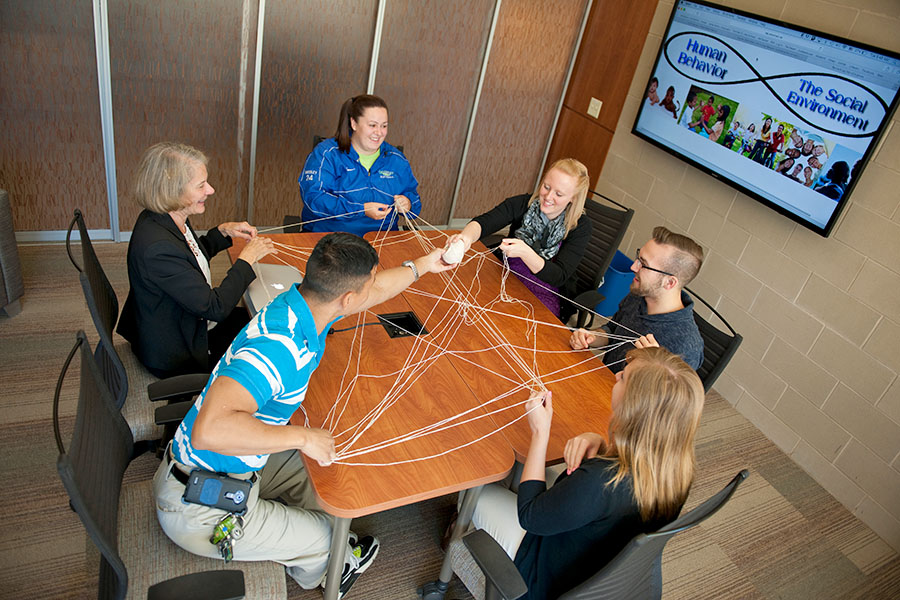 students and professor creating a web of strings between themselves