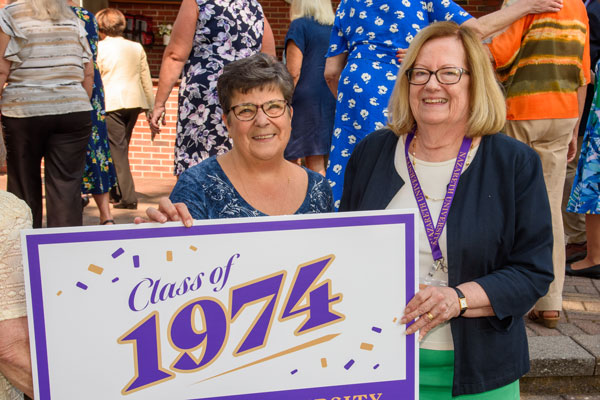 Class members hold Class of 1974 sign at their 50th Reunion